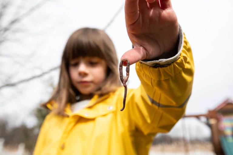 a girl holds a worm